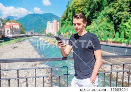 Man on the embankment of a mountain river in a European city. 57605094