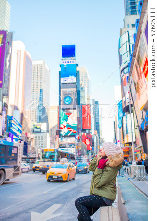 New York City woman as Times Square tourist or young happy woman visiting. Beautiful young happy New York City woman as Times Square tourist or young happy woman visiting. Beautiful young happy 57605111