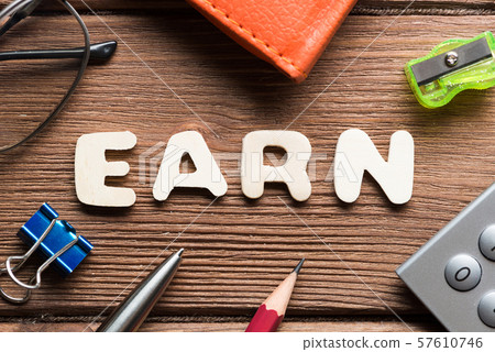 Earn word on wooden table and office stationary around Earn word on wooden table and office stationary around 57610746