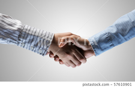 Business handshake as idea for unity and cooperation or greeting. Mixed media Business handshake as idea for unity and cooperation or greeting. Mixed media 57610901