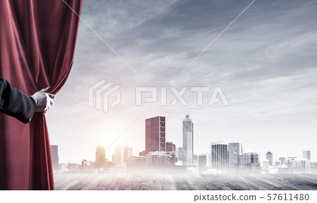 Business city behind red curtain and hand holding it Business city behind red curtain and hand holding it 57611480