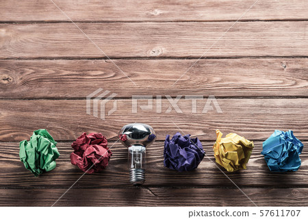 Ideological concept with wastepaper light bulb on wooden table Ideological concept with wastepaper light bulb on wooden table 57611707