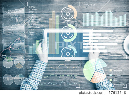 Business workplace with tablet device coffee cup and media graphs and diagrams Business workplace with tablet device coffee cup and media graphs and diagrams 57613348