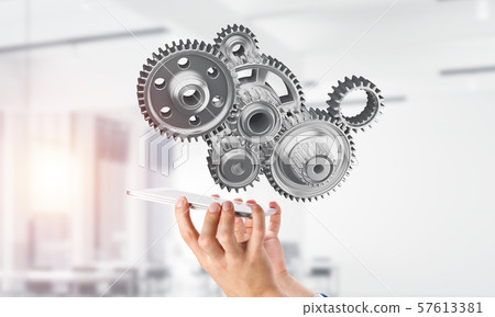 Engine mechanism in male hands as symbol for cooperation or teamworking. Mixed media 57613381