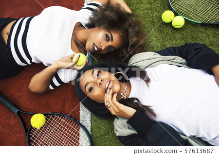 young pretty girlfriends hanging on tennis court, fashion stylish dressed swag, best friends happy young pretty girlfriends hanging on tennis court, fashion stylish dressed swag, best friends happy 57613687