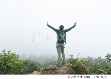 Successful hiker open arms at spring forest Successful hiker open arms at spring forest 57618019