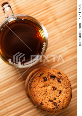 Oatmeal cookies with pieces of chocolate and a mug 57618680