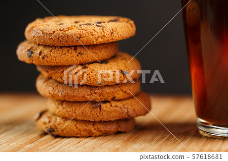 Oatmeal cookies with pieces of chocolate and a mug Oatmeal cookies with pieces of chocolate and a mug 57618681