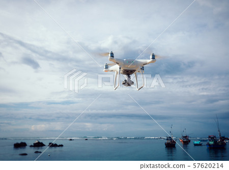 Drone flying over the sea under cloudy sky Drone flying over the sea under cloudy sky 57620214