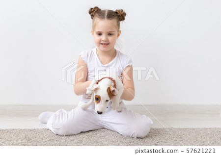 Dogs, pets and animal concept - Little child girl sitting with puppy Jack Russell Terrier Dogs, pets and animal concept - Little child girl sitting with puppy Jack Russell Terrier 57621221