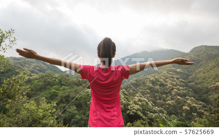 young woman  feel free at forest mountain top 57625669