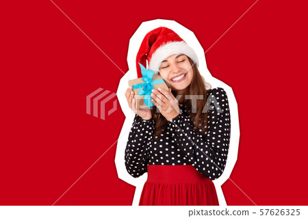 Happy woman in chistmas hat hugs a gift Happy woman in chistmas hat hugs a gift 57626325