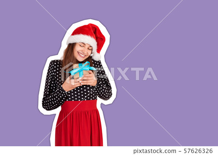 Happy woman in chistmas hat hugs a gift Happy woman in chistmas hat hugs a gift 57626326
