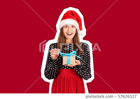 Happy woman in chistmas hat hugs a gift Happy woman in chistmas hat hugs a gift 57626327