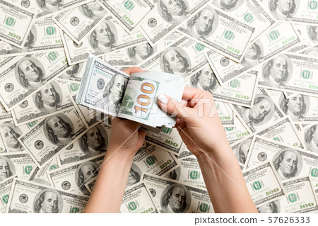Top view of female hands counting money on dollar Top view of female hands counting money on dollar 57626333