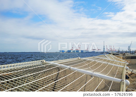Wire mesh fence on the revetment pierced by a typhoon 57626596