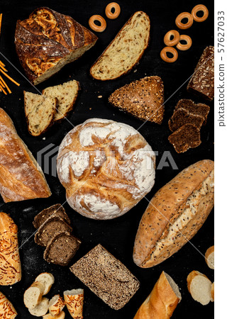 Assortment of different types of bread on a black background. Top view 57627033