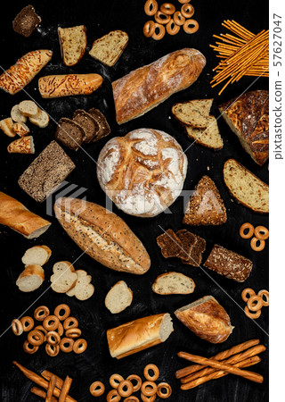 Assortment of different types of bread on a black background. Top view 57627047
