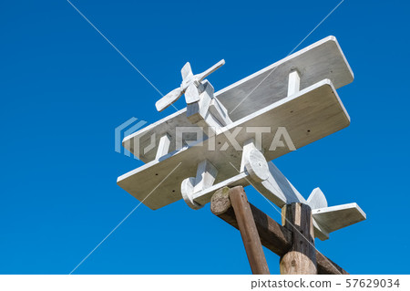 Small wooden plane on blue sky background. 57629034