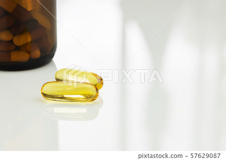 Supplement omega 3 fish oil capsules on white table Supplement omega 3 fish oil capsules on white table 57629087