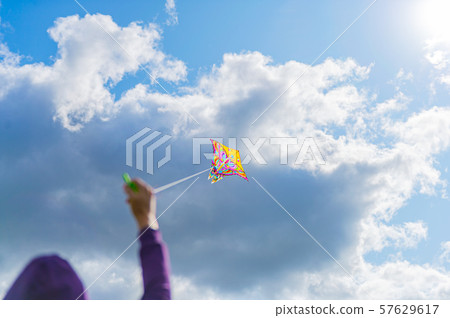 womans handing the rope while playing kite in the sky, enjoy lifestyle in freedom. womans handing the rope while playing kite in the sky, enjoy lifestyle in freedom. 57629617