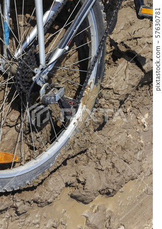 the Bicycle wheel is stuck in the mud. Close up 57630781