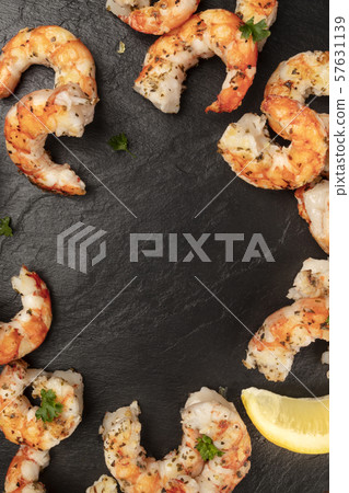 Fried shrimps with lemon, shot from the top on a black background, forming a frame for copyspace Fried shrimps with lemon, shot from the top on a black background, forming a frame for copyspace 57631139
