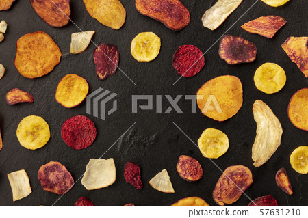 Dry fruit and vegetable chips, healthy vegan snack, an organic food flat lay pattern on a black Dry fruit and vegetable chips, healthy vegan snack, an organic food flat lay pattern on a black 57631210