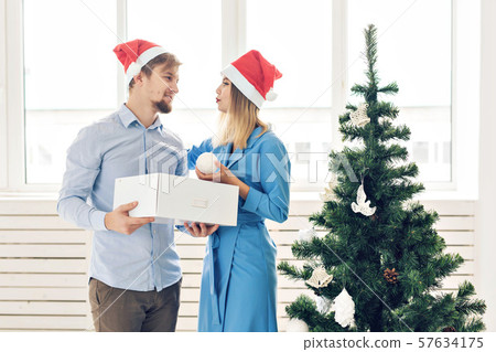 Winter holidays and family concept - Happy young couple near Christmas tree at home 57634175