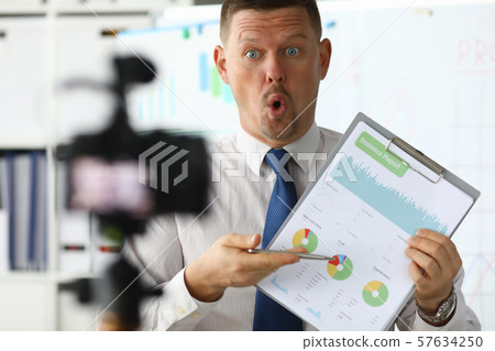 Astonished businessman hold in hand business Astonished businessman hold in hand business 57634250