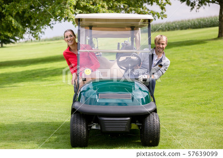 Happy couple sitting in the golf cart peeking Happy couple sitting in the golf cart peeking 57639099