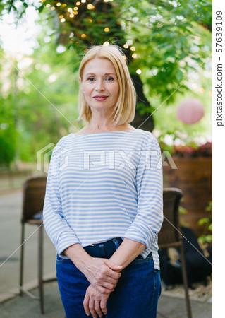 Portrait of beautiful woman in casual clothes standing in open air cafe in city 57639109