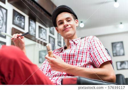 Baber holding straight razor and shaving brush 57639117