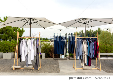 Racks with clothes outdoors. Designer sells Racks with clothes outdoors. Designer sells 57639674