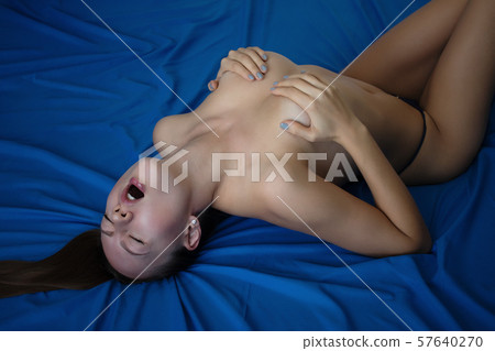 Sexy naked woman lying on back in thongs 57640270