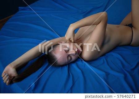 Sexy naked woman lying on back in thongs 57640271