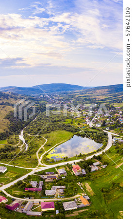 Vertical landscape of settlement in valley between mountains. Sunset time, end of summer. Aerial Vertical landscape of settlement in valley between mountains. Sunset time, end of summer. Aerial 57642109