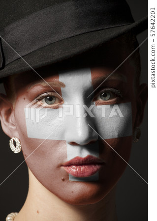 Woman face with painted Swiss flag 57642201