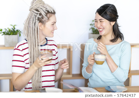 Japanese women chatting with Russian friends while enjoying latte art Japanese women chatting with Russian friends while enjoying latte art 57642437