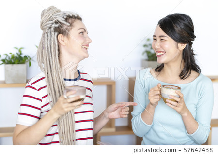 Japanese women chatting with Russian friends while enjoying latte art Japanese women chatting with Russian friends while enjoying latte art 57642438