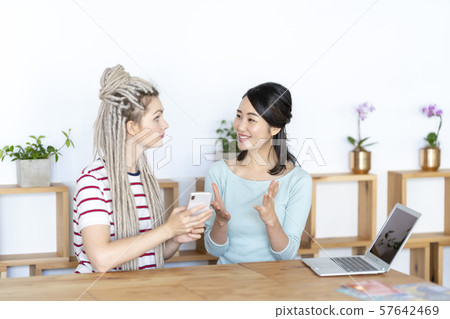 A woman explaining the splendor of Japan to foreign tourists by gesturing 57642469