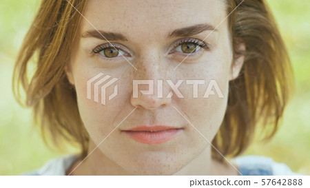 Face close-up of a young girl with freckles. 57642888