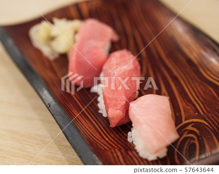Set of three tuna sushi on a wooden plate Set of three tuna sushi on a wooden plate 57643644
