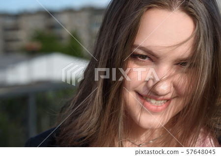 Portrait of brunette girl. Girl in black jacket with long hair on the street. Plus size model 57648045