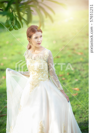 Beautiful portraits with natural light asian woman bride in wedding dress in nature meadow flower Beautiful portraits with natural light asian woman bride in wedding dress in nature meadow flower 57651251