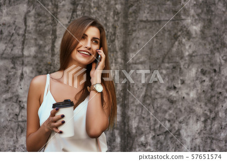 Beautiful stylishly dressed girl posing over concrete background 57651574