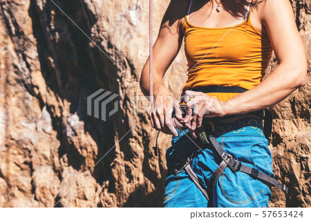 Woman making knot. 57653424
