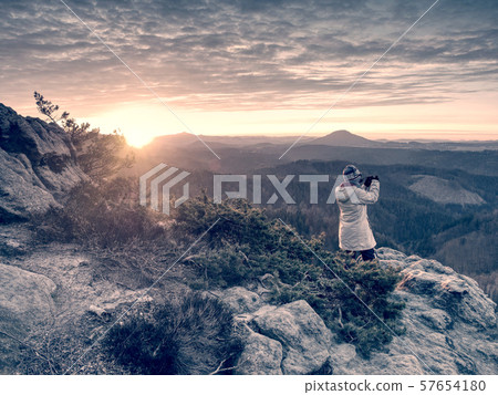 Danger rocky edge. Artist woman with camera on 57654180