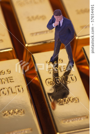 Miniature Businessman on Gold Bar Miniature Businessman on Gold Bar 57654491