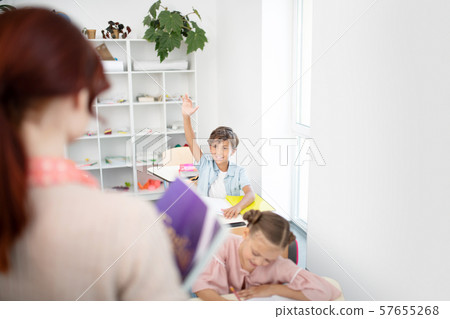 Teacher listening to smart schoolboy answering question Teacher listening to smart schoolboy answering question 57655268